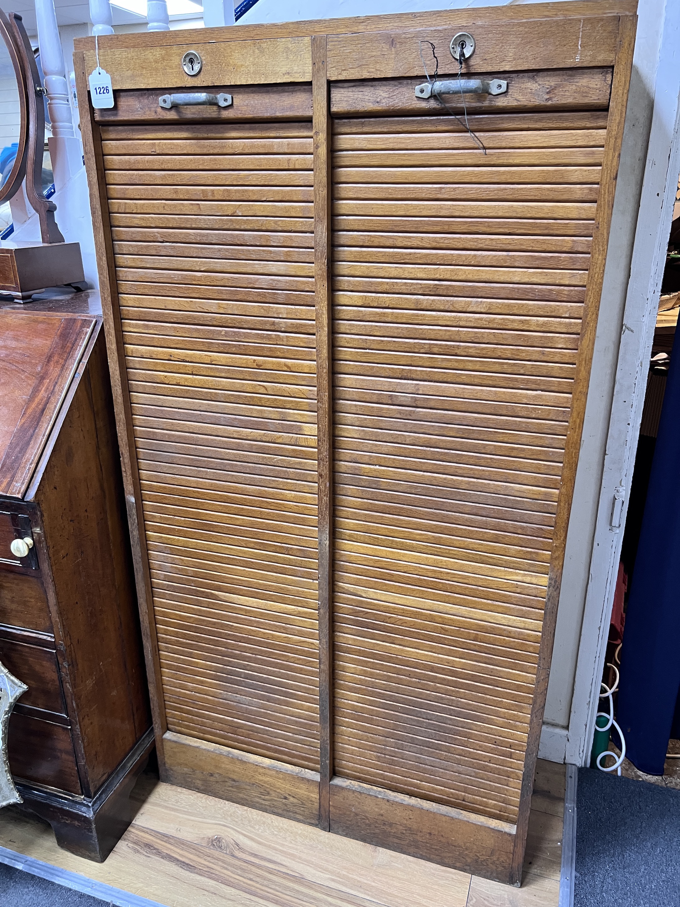 An early 20th century golden oak double tambour front office cabinet, width 82cm, height 150cm